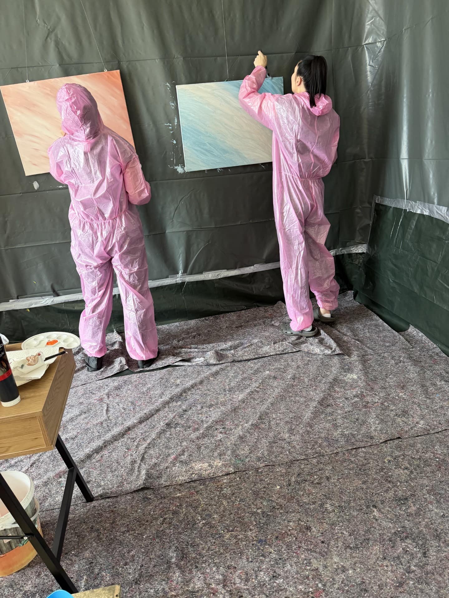 Zwei Personen beim Action Painting an Leinwänden