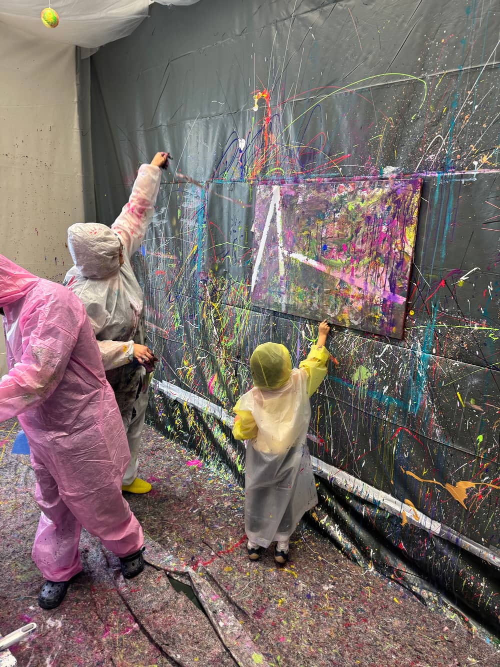 Familie malt gemeinsam an der Splash-Wand