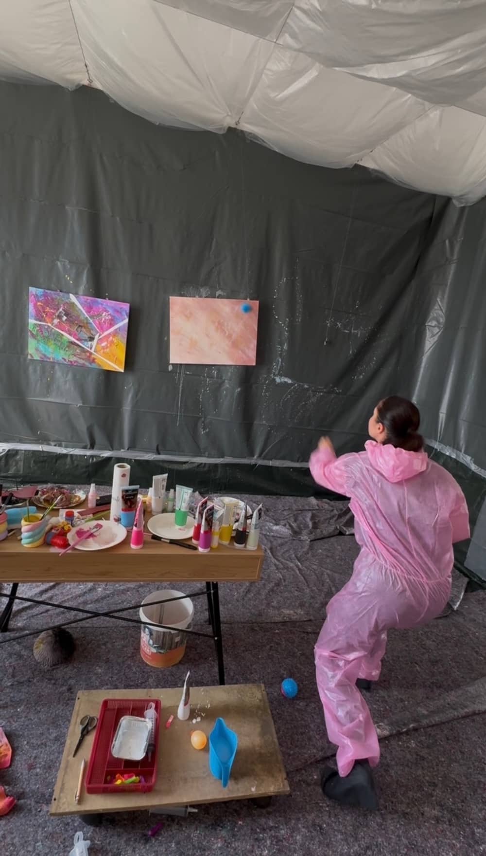 Gast im Schutzanzug wirft Farbe auf die Leinwand
