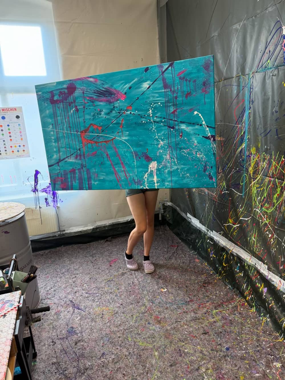Gast hält ihr fertiges türkisfarbenes Kunstwerk